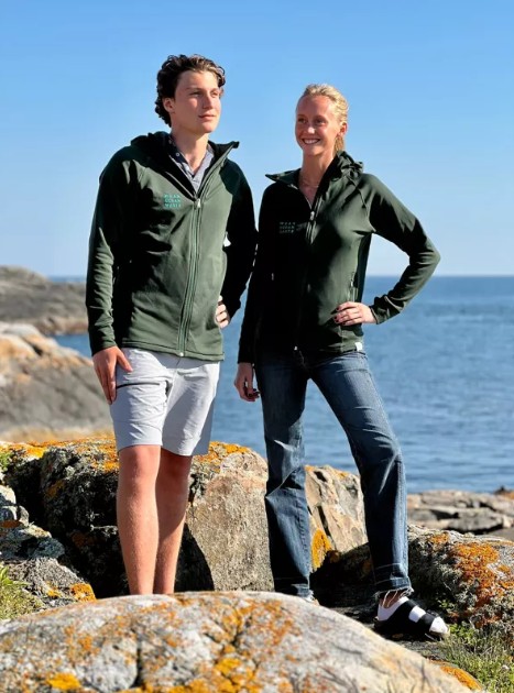 Två personer bär hållbara kläder från Reparell och står vid havet, där funktion möter stil i en miljömedveten design.